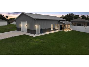 Exterior angle of a gray house with a garage, screened porch, and trimmed green grass at 369 Hyacinth St, Port Charlotte, FL 33954