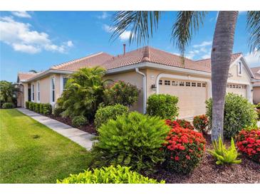 Beautiful home exterior with lush landscaping, a tile roof, and an attached two-car garage at 4567 Whispering Oaks Dr, North Port, FL 34287