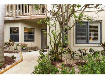 Inviting home entrance with well-maintained landscaping and a cozy bench near the front door at 5230 Lake Arrowhead Trl # 29, Sarasota, FL 34231