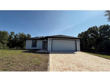 Charming single-story home featuring a brick driveway, a two-car garage, and a well-maintained front lawn at 7052 Legion St, Port Charlotte, FL 33981