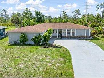 Charming single-story home with a well-manicured lawn, long driveway, and a welcoming facade at 123 Annapolis Ln, Rotonda West, FL 33947