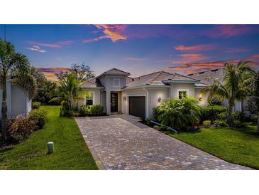 Charming single-Gathering home featuring a paver driveway, well-maintained landscaping, and a tile roof at 14684 Cherry Blossom Way, Punta Gorda, FL 33955