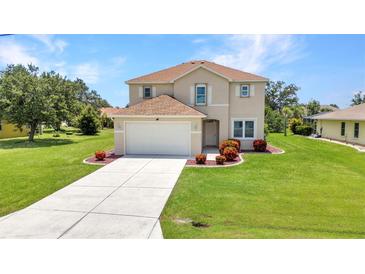 Charming two-story home features a well-manicured lawn and attached two-car garage at 200 Valdiva St, Punta Gorda, FL 33983