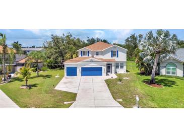 Two-story home boasting a 2-car garage, manicured lawn, and tasteful landscaping at 2210 Mauritania Rd, Punta Gorda, FL 33983
