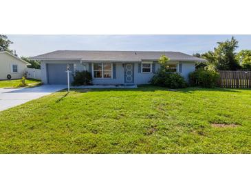 Charming single-story home with a well-maintained lawn, attached garage and cheerful neutral exterior paint at 3270 Ithaca St, Port Charlotte, FL 33952