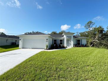 Charming single-story home with a well-manicured lawn, attached garage, and lovely architectural details at 4863 Las Almanos Ave, North Port, FL 34288