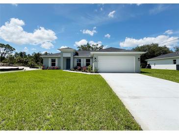 Charming single-story home with well-manicured lawn and a two-car garage on a bright sunny day at 4895 Las Almanos Ave, North Port, FL 34288