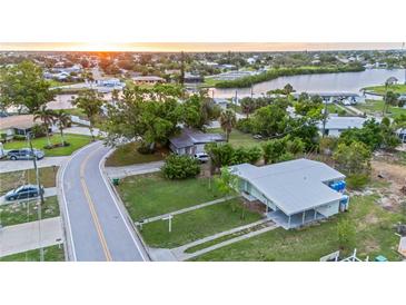 Lovely single-story home with mature trees, green lawn, and a convenient covered parking area at 180 Palmetto Ne Cir, Port Charlotte, FL 33952