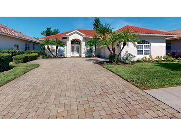 Charming home featuring a well-manicured front yard, brick driveway, and a tile roof at 421 Marsh Creek Rd, Venice, FL 34292