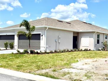 Charming single-story home features a well-manicured lawn, two-car garage, and neutral stucco exterior at 8706 Seasalt Loop, Englewood, FL 34224