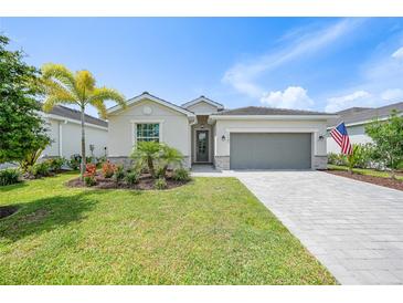 Charming single-story home featuring a paver driveway, two-car garage, and meticulously maintained landscaping at 11383 Burgundy Dr, Venice, FL 34293