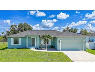 Charming single-story home featuring a well-manicured lawn and an attached two-car garage at 12112 Helios Ave, Port Charlotte, FL 33981