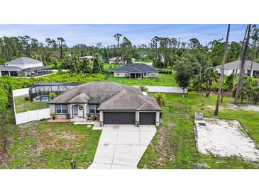 Charming single-story home featuring a spacious driveway, three-car garage, and beautiful landscaping at 1546 Gourmet Rd, North Port, FL 34288