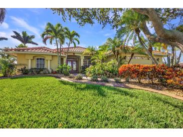Beautiful home featuring a well-manicured lawn, vibrant landscaping, and a charming red tile roof at 17188 Cape Horn Blvd, Punta Gorda, FL 33955