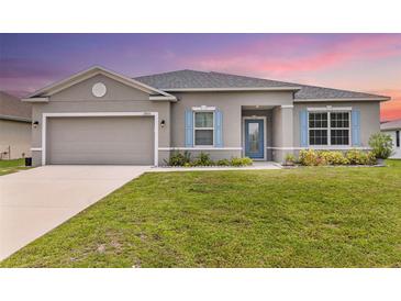 Charming one-story home with blue shutters, manicured lawn, and inviting curb appeal at 17200 Gulfspray Cir, Port Charlotte, FL 33948