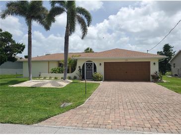 Charming single Gathering home with a two-car garage, beautiful lawn, and mature palm trees at 2220 Broad Ranch Dr, Port Charlotte, FL 33948
