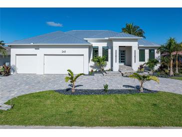 Beautiful home featuring a three-car garage, pristine landscaping, and a modern architectural style at 245 Lido Dr, Punta Gorda, FL 33950