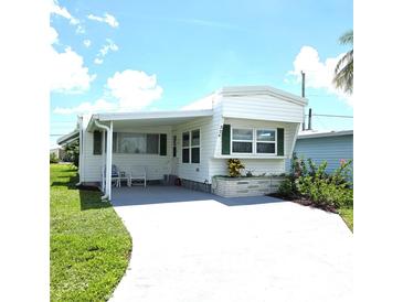 Charming single-story home with a covered porch and well-maintained landscaping at 326 Trailorama Dr, North Port, FL 34287