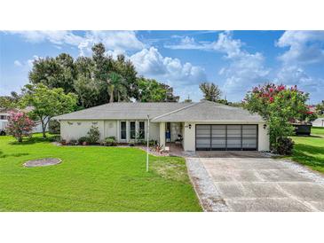 Charming single-story home featuring a well-maintained lawn, mature landscaping, and a two-car garage at 475 Whippoorwill Dr, Venice, FL 34293