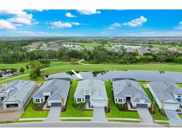 Stunning aerial view of a modern home with lush landscaping and a serene lake view at 14846 Contenta Loop, Bradenton, FL 34211