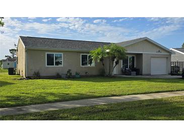 Charming single-story home with a well-manicured lawn, mature palms, and an attached single-car garage at 2552 Roxbury Cir, North Port, FL 34287