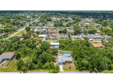 Sprawling property with a pool and lush landscaping in a quiet, residential neighborhood at 732 Haleybury St, Port Charlotte, FL 33948