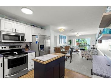 Open floor plan featuring a modern kitchen with stainless steel appliances and a cozy living area with a balcony at 915 Beach Rd # 215, Siesta Key, FL 34242