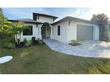 Modern single-story home with gray paver driveway and landscaping at 124 Hercules Dr, Rotonda West, FL 33947