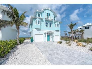 Beachfront home with teal exterior and paver driveway at 261 N Gulf Blvd, Placida, FL 33946