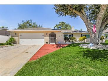 Single-story home with red walkway, garage, and mature tree at 1361 Newton St, Port Charlotte, FL 33952