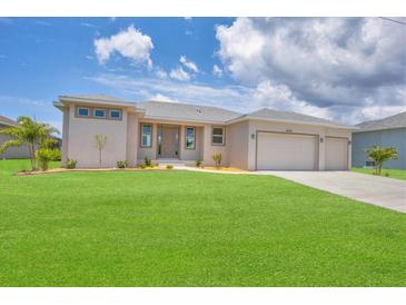 New construction home with a two-car garage and lush lawn at 8343 Olsen St, Port Charlotte, FL 33981