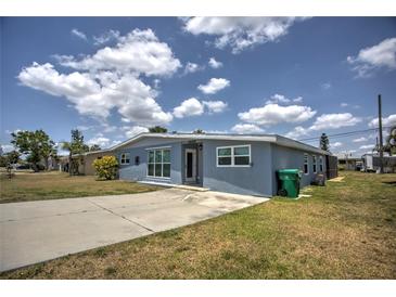Ranch-style home with light blue exterior and a spacious front yard at 22216 Midway Blvd, Port Charlotte, FL 33952