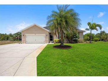 Tan one-story house with a two-car garage and lush lawn at 15889 Viscount Cir, Port Charlotte, FL 33981