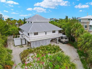 Elevated view of a two-story home with gray roof at 51 Palm Dr, Placida, FL 33946