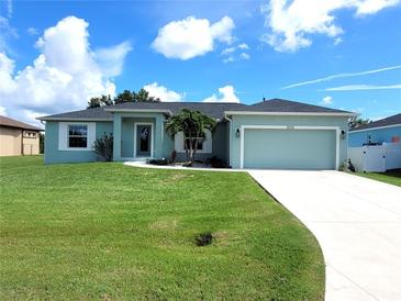 Charming light teal house with a two-car garage at 12112 Helios Ave, Port Charlotte, FL 33981