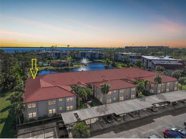 Aerial view of condo building with parking and water view at 23465 Harborview Rd # 1021, Punta Gorda, FL 33980