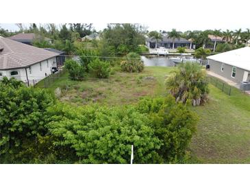 Waterfront vacant lot, surrounded by established homes and lush landscaping at 8356 Tecumseh Cir, Port Charlotte, FL 33981