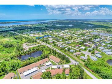 Aerial view of a community with waterfront access and lush landscaping at 6796 Gasparilla Pines Blvd # 48, Englewood, FL 34224