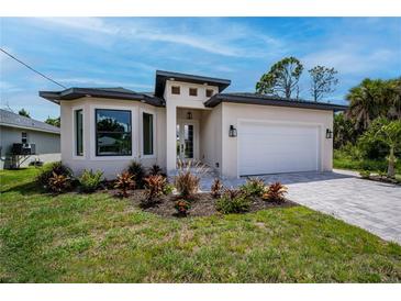 Modern one-story home with a two-car garage, landscaping and paver driveway at 205 Cougar Way, Rotonda West, FL 33947