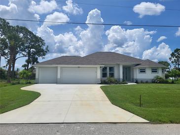 Charming single-story home with a three-car garage, lush lawn, and a well-maintained landscape at 261 Broadmoor Ln, Rotonda West, FL 33947