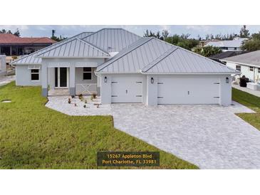 Two-story home with attached two-car garage and metal roof at 15267 Appleton Blvd, Port Charlotte, FL 33981