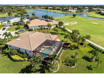 Stunning aerial view of a home with a screened pool, lush landscaping, and golf course frontage at 10 Coral Creek Pl, Placida, FL 33946