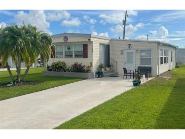 Single-wide mobile home with landscaped yard and spacious driveway at 208 Marlette Dr, North Port, FL 34287