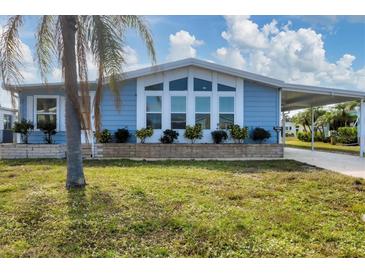 Cute light blue home with covered carport and well-manicured lawn at 740 Summersea Ct, Englewood, FL 34223