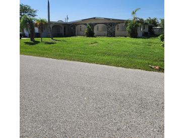 Ranch-style home with a well-maintained lawn at 1455 Crest Dr, Englewood, FL 34223