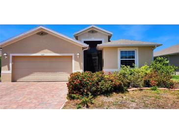 Charming single-story home featuring a well-manicured lawn and a brick-paved driveway leading to an attached two-car garage at 5229 Canyonland Way, Venice, FL 34293