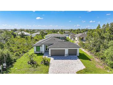 New construction home with paved driveway, two-car garage, professional landscaping, and modern design at 9262 Genesee St, Port Charlotte, FL 33981