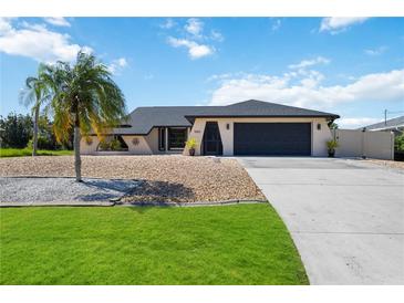 House exterior with palm tree, driveway, and landscaping at 9273 Carnation Ave, Englewood, FL 34224