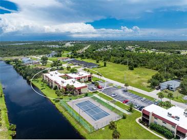 Aerial view of condo community with tennis court and canal at 66 Boundary Blvd # 238, Rotonda West, FL 33947