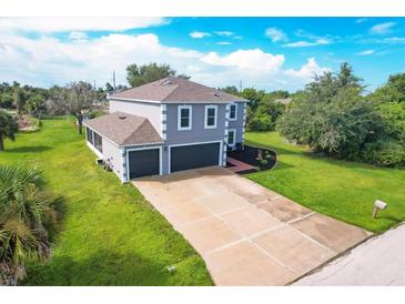 Two-story home with an attached two-car garage, long driveway, and lush green lawn at 13401 Galveston Ave, Port Charlotte, FL 33981